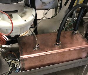 The new shinny copper tank installed in the bottom of the dishwasher unit.