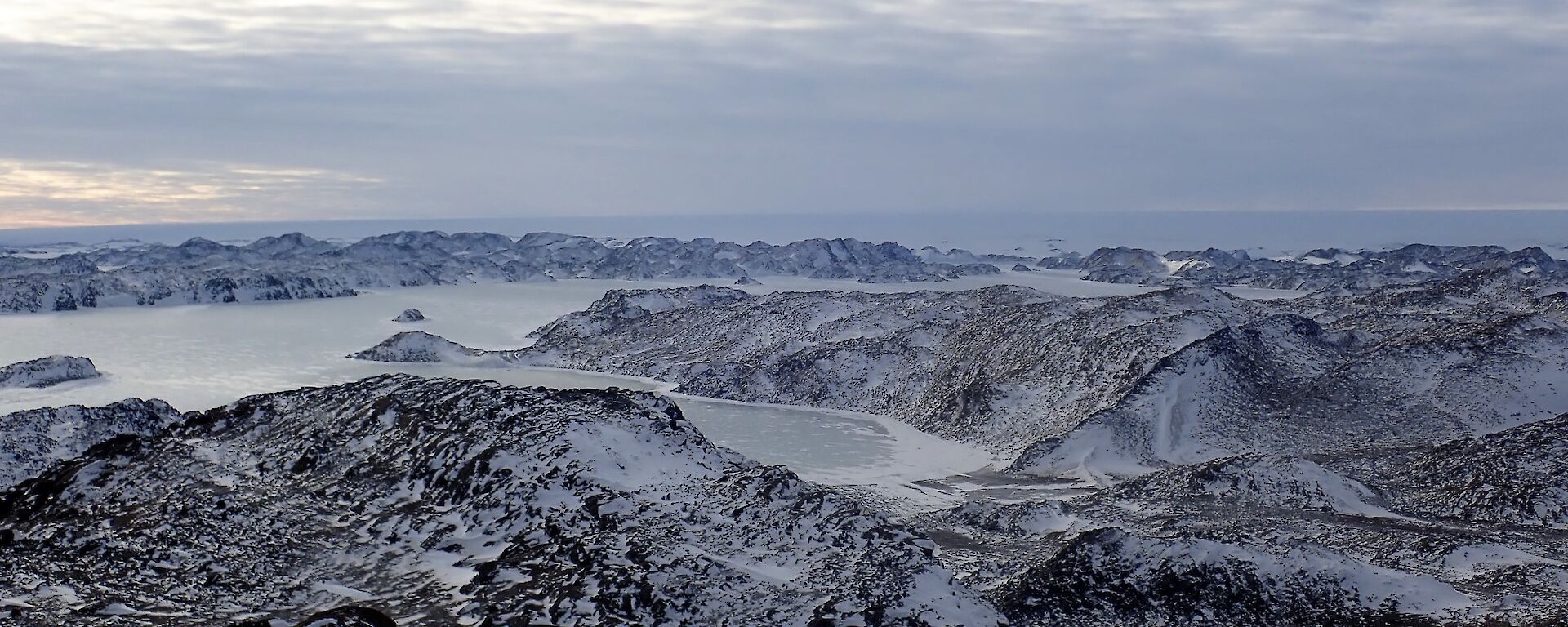 Looking from the top of Lied Bluff over the Vestfold lightly snow covered rocky valleys and fjords.