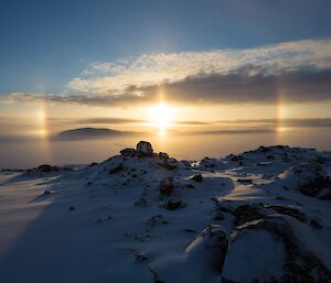 Sun reflecting in the floating ice crystals forming a large circle around the sun with bright colourful sections either side.
