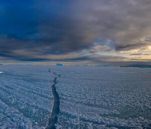 A crack in the sea ice extending off into the distance.