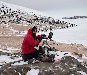 Trevor busy servicing a penguin monitoring camera on Magnetic Island with views of the sea ice