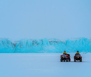 The blue coloured Sørsdal glacier in the distance with two quad bikes in the foreground.