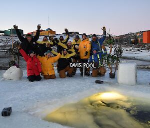 Group photo of the 12 expeditioner that did the swim near the swim hole with the station in the background.