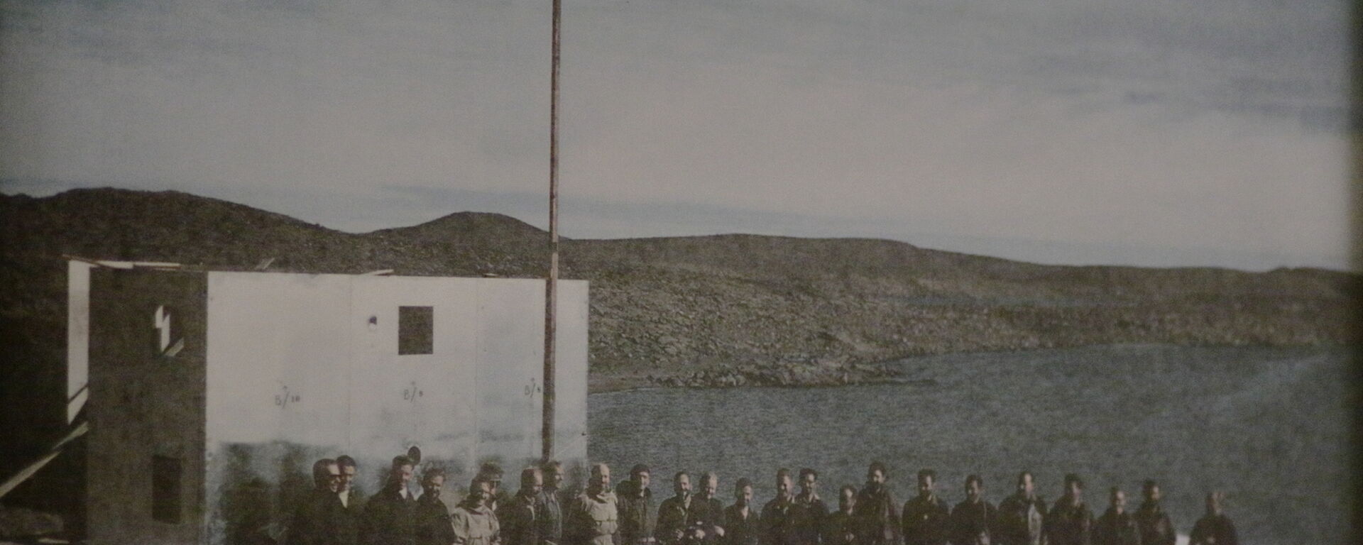 An early faded photograph of the men that established Davis station at the opening ceremony in 1957.