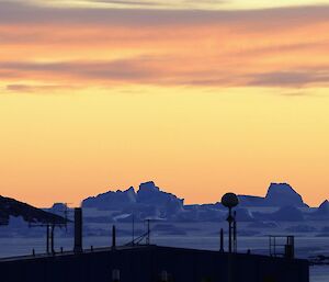 The colours of sunrise over the Meteorology building, with icebergs in the mid-ground.