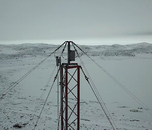 Photo used to inspect the top of a 50 metre mast with snow covered Heidemann Bay in the background.