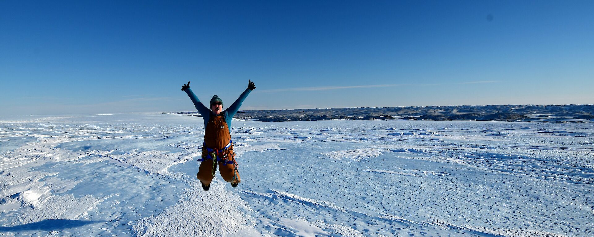 Woman jumping for joy in icy landscape