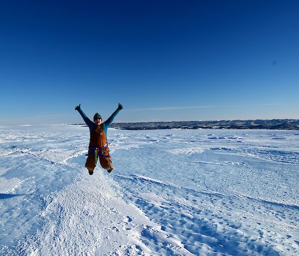 Woman jumping for joy in icy landscape