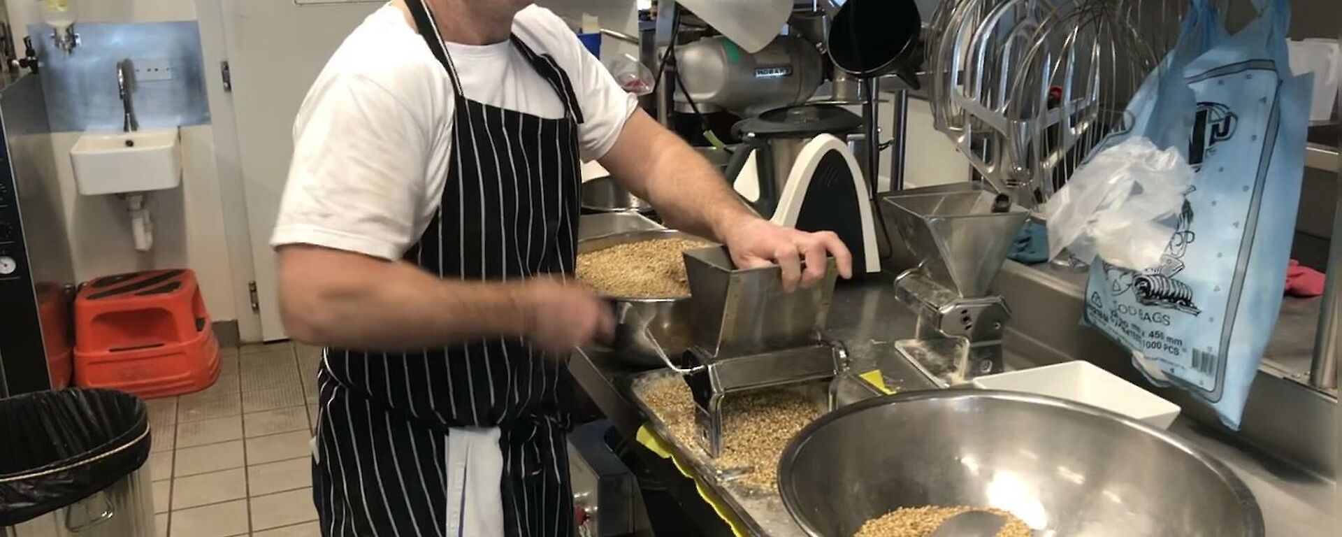 Putting the whole grain through a small hand milling machine.