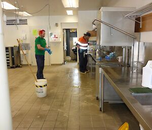 Graham and Terry cleaning the empty kitchen floor.