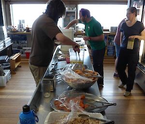 Expeditioners prepare lunch wraps of roast chicken, prawns, salad and dips outside of the kitchen as it is closed for cleaning.