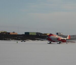 The Basler DC 3 landing on the sea ice with Davis station in the background.