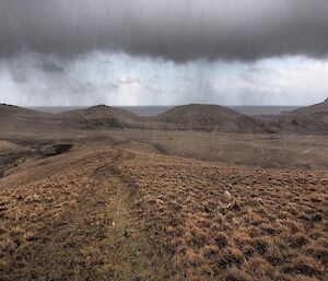 Dark clouds and rain begin to drench a plateau on Macquarie Island