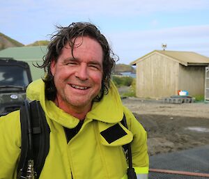 An expeditioner without his breathing apparatus smiles at the camera