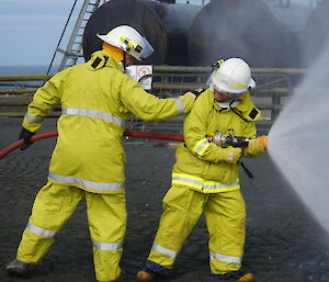 Paul and Benny use a shielding spray to approach the fire
