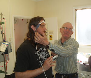 Sean is fitted with monitoring equipment that fits over his forehead, by the doctor who is explaining his actions