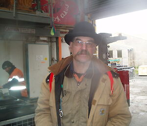 Male expeditioner in bowler’s hat and large moustache looks at the camera