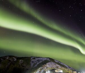 Green aurora over Wireless Hill with station buildings in foreground at night