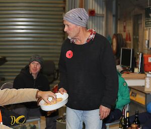 Man in black jumper serving food at barbeque