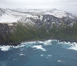 Aerial view of snow covered island with ocean in foreground