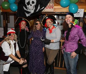 Group of woman in pirate outfits posing for picture.