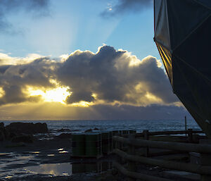 Rays of light beaming from clouds with ANARESAT in foreground