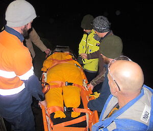 Expeditioners moving the stretcher with wheel in the dark