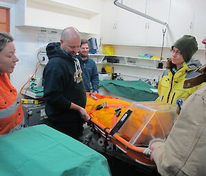 Expeditioners moving a stretcher into the surgery