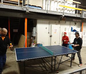 Four people playing table tennis