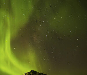 An aurora in the sky over the top of a hill on station