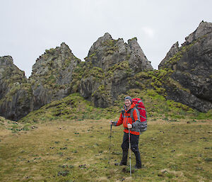 Rich standing in front of rock stacks in red jacket