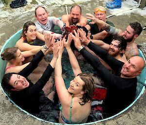 Expeditioners in the spa raising hands