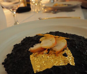 Champagne and squid ink risotto with seared lobster and gold leaf