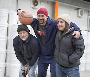 Duncan , Andrea and Nick under the basketball hoop with a ball