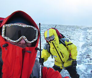 Two expeditioners on snowy land wearing goggles