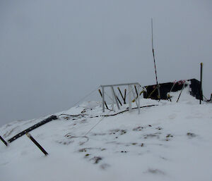Assortment of technical equipment like antennas on a snowy hill.