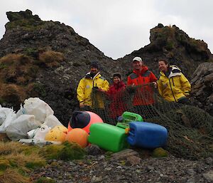 Four expeditioners standing with plastic drums and fishing nets