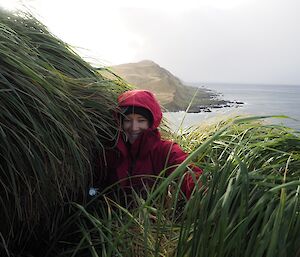 Anna in a red coat with a vie out to the ocean in rear