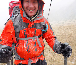 Rich in orange hiking jacket with snow falling
