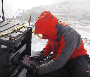 Rich sitting with equipment in snow