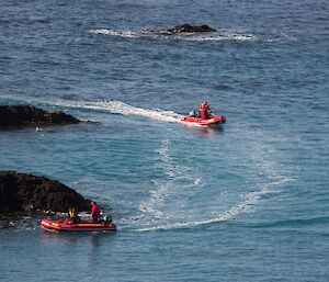 Two rubber boats zoom through the water