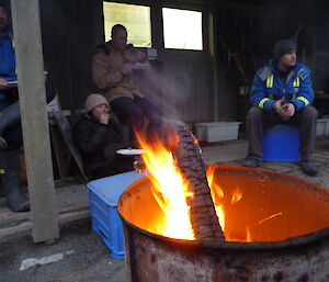 Expeditioners sitting around fire