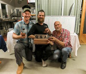 The winning quiz night team of Rich, Dan and Nick, holding trophies