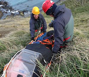 Ben and Justin with Furno stretcher on hillside with Garden Cove below