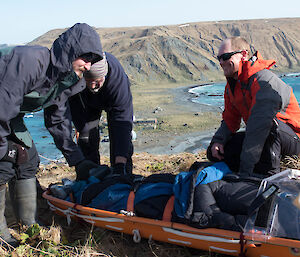 Expeditioners gathered around the stretcher