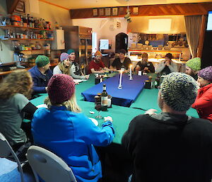 Expeditioners sitting at table wearing colored beanies