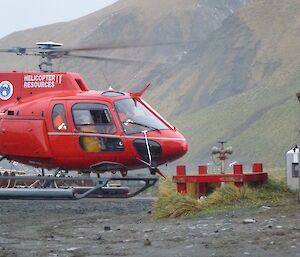 Penguin on nest with helicopter on the ground