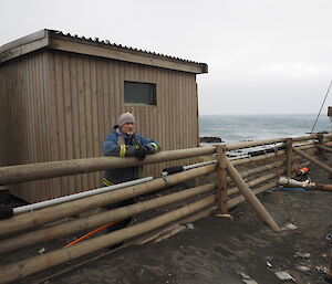 Nick leaning on a fence in blue jacket