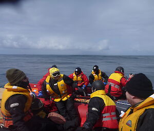 Taking a break during boating — expeditioners sitting in IRBs wearing life jackets