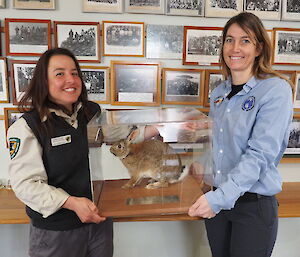 Andrea and Jacque hold a rabbit in a glass case